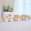 Square lifestyle scene of a wooden cat train bed with a cat