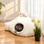 Gray cat resting inside a white polar bear pet cave bed