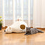 Gray cat relaxing beside a white polar bear pet cave bed