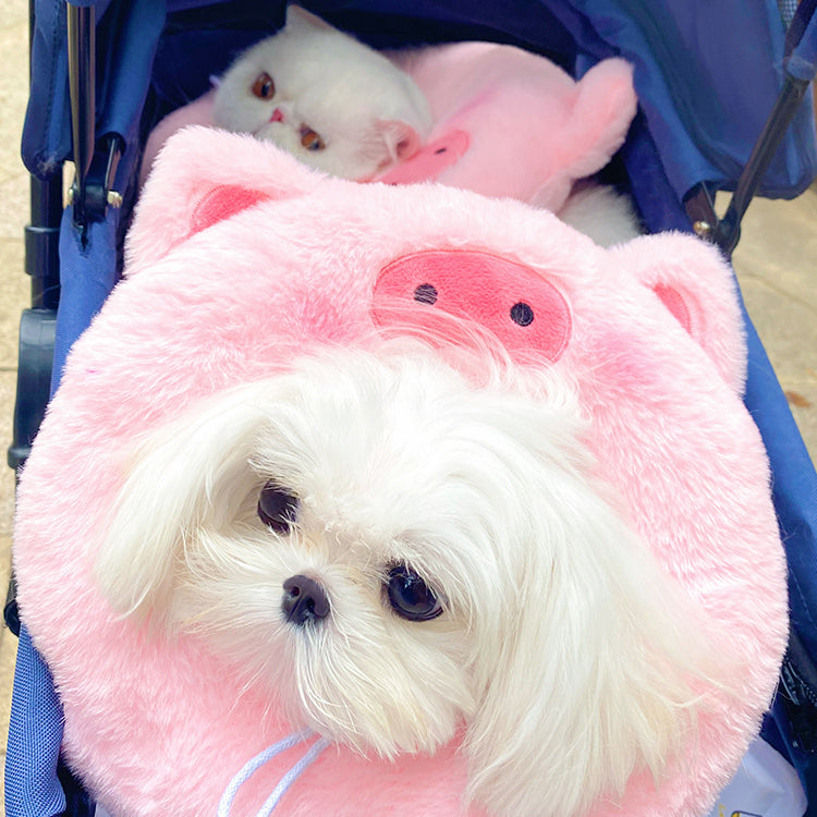 Small dog wearing a pink pig plush pet neck warmer
