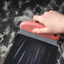 KIMPETS Coral Orange pet hair remover brush collecting loose pet hair from black fabric