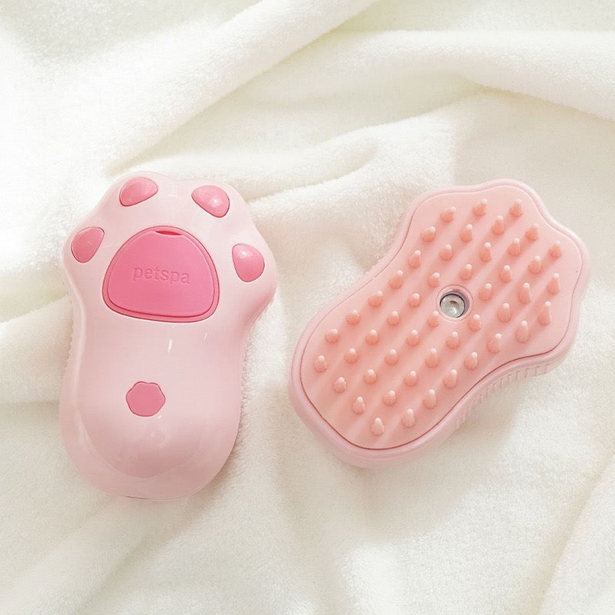 Pink cat-paw brush front and back on a white towel