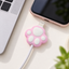 Pink cat paw silicone cable protector attached to a charging cable