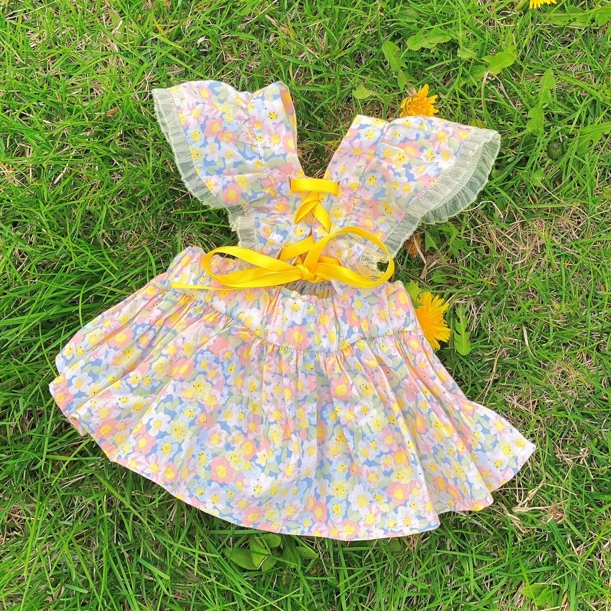 Monin & B1GGERFISH floral pet dress laid flat on grass [Gallery: Lifestyle]