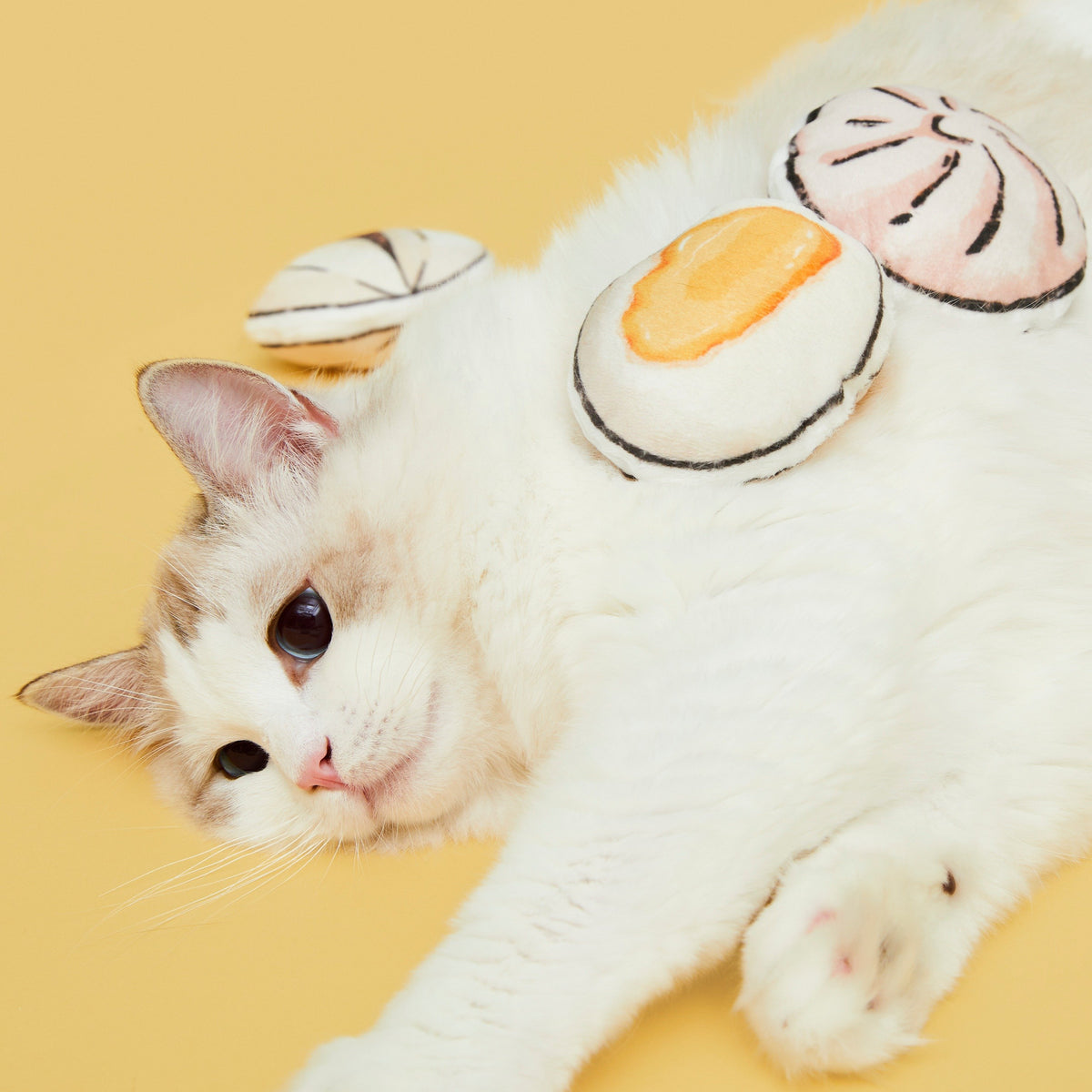 Cat lying beside Vetreska Chinese dim sum plush cat toys